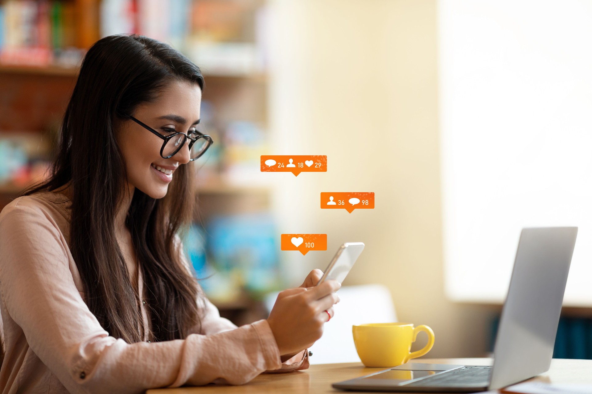 Happy latin female blogger using smartphone with social media notification icons, sitting in cafe, free space